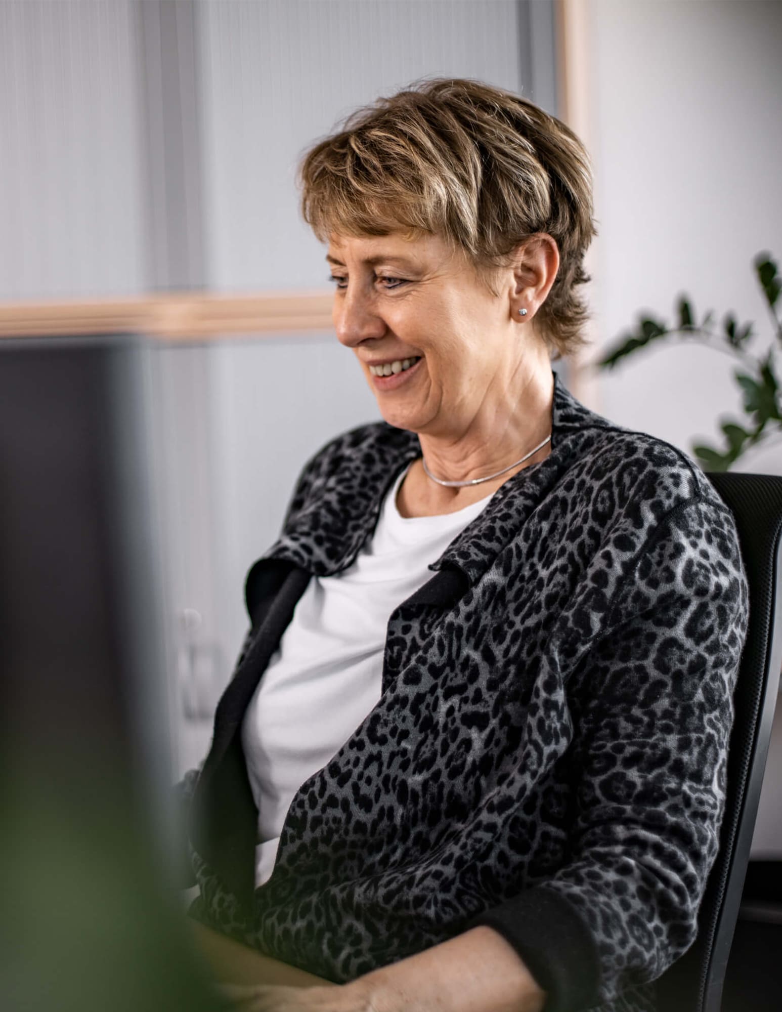 Person am Schreibtisch mit Laptop in Büro – symbolisiert professionellen Kundenkontakt und Unterstützung.
